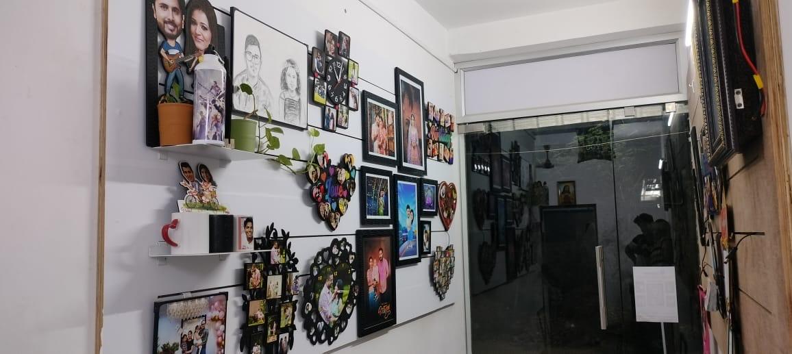 Studio wall filled with custom photo clocks, caricature cut-outs and collage frames
