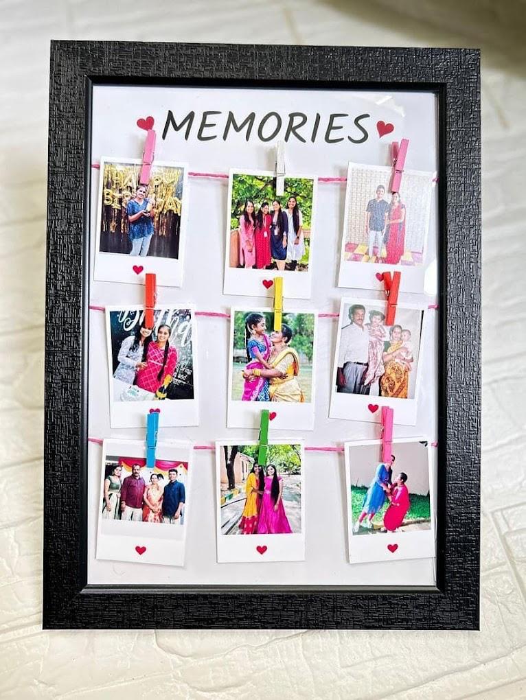 Black frame with polaroid photos pinned on strings under the word Memories